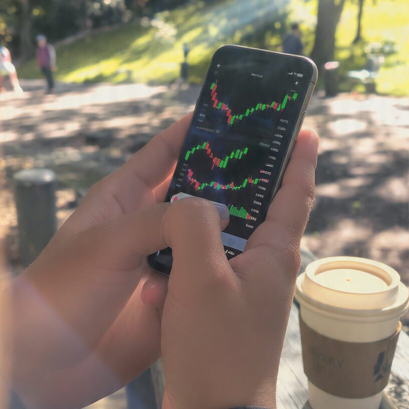  person checking investments on phone outdoors casual finance